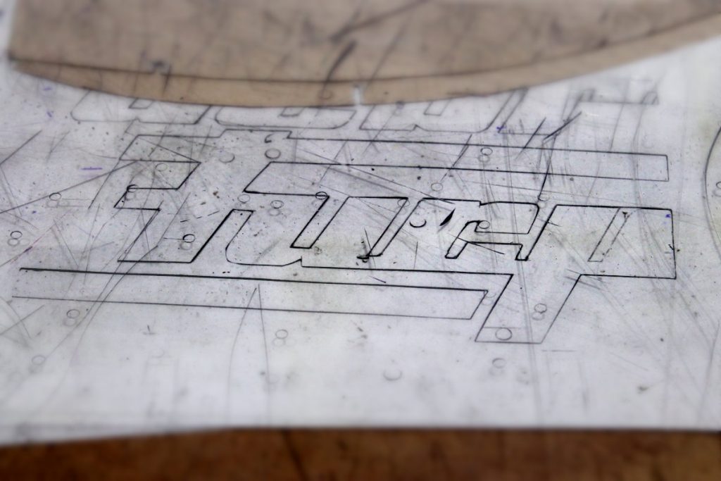 Un logo tracé à la main sur une table de couturière