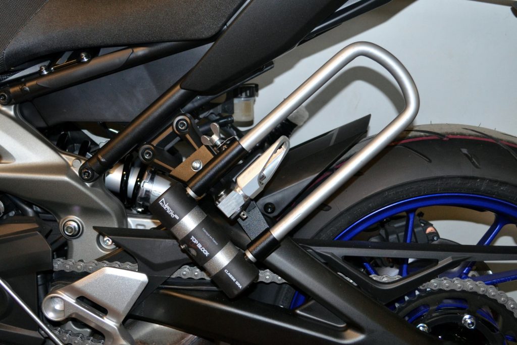 Les supports U comme ce modèle Top Block pour Yamaha MT-09 permettent de transporter un antivol à moto facilement
