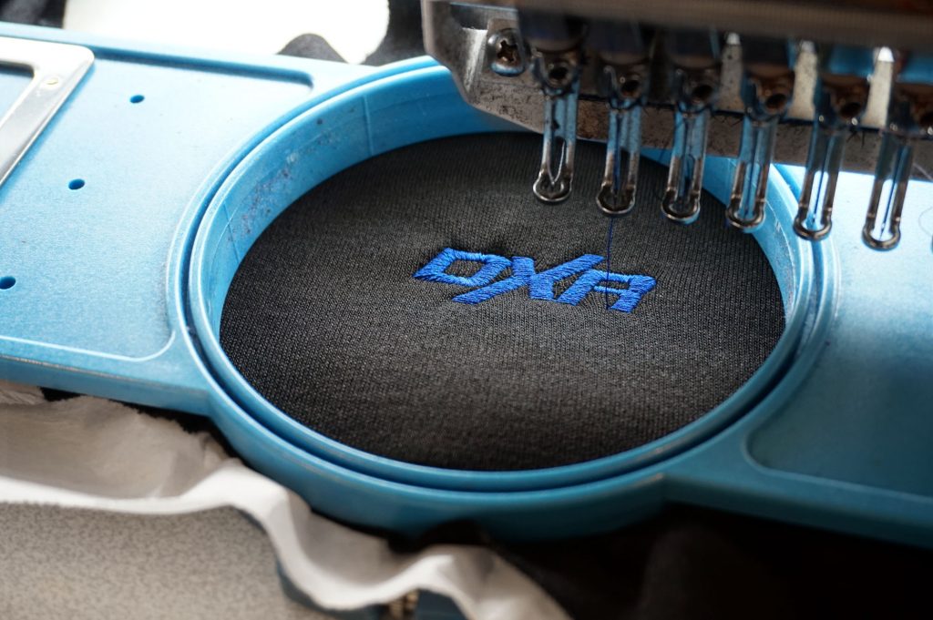 Broderie automatisée d’un logo DXR sur la poitrine d’un haut DXR Vaillant