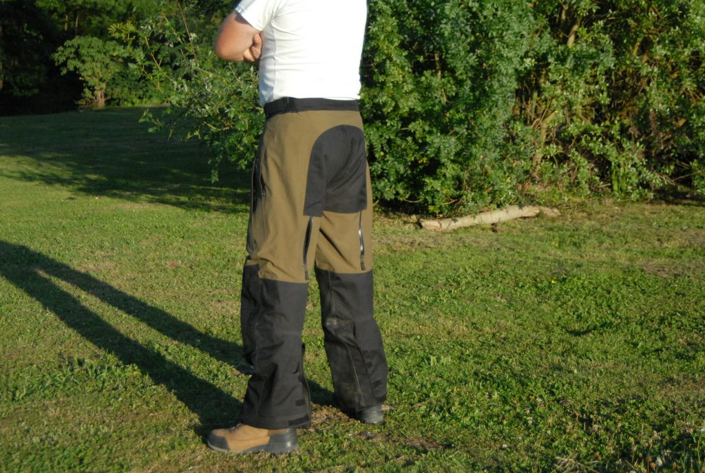 Cette vue de trois-quarts arrière permet de voir le réglage des bas de jambes par velcro du pantalon Klim Traverse