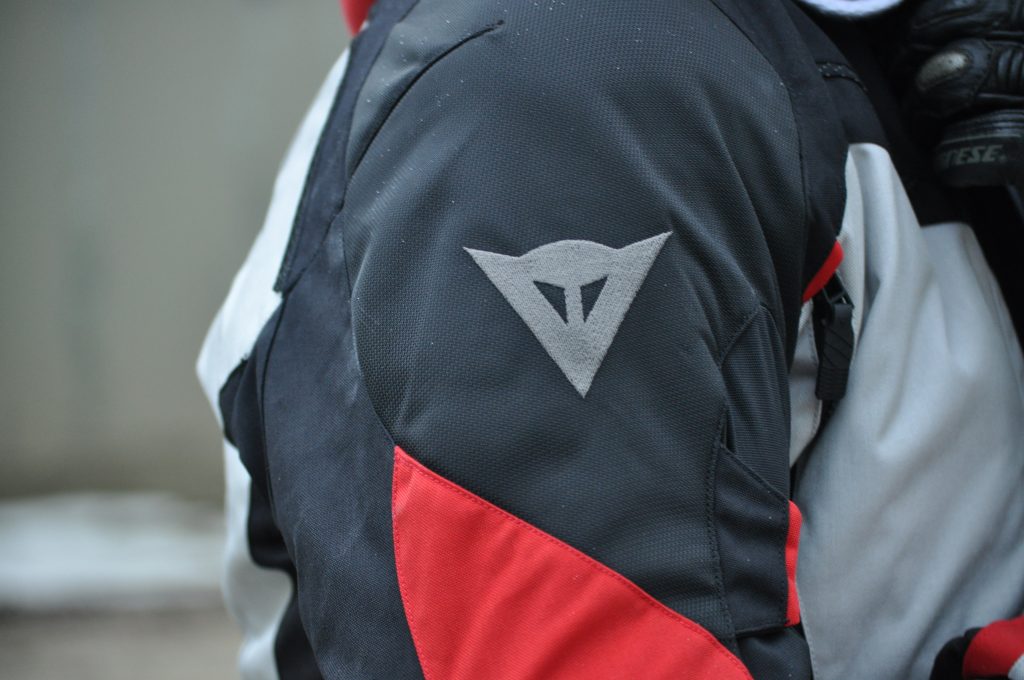 Le logo Dainese, présent sur l’épaule de la veste Dainese TEMPEST 2 D-DRY