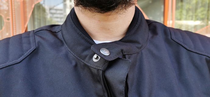 le col cerclé de néoprène avec son bouton pression pour un look néo-rétro 