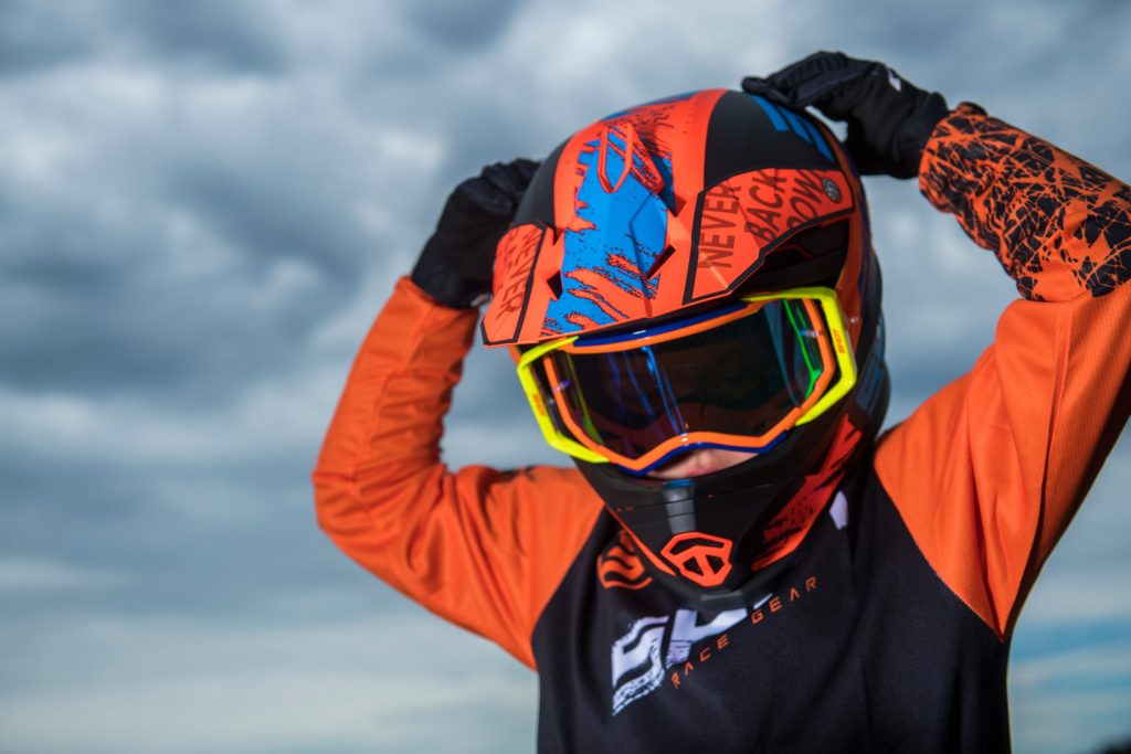Enfant enfilant son casque moto avec un masque à sa taille