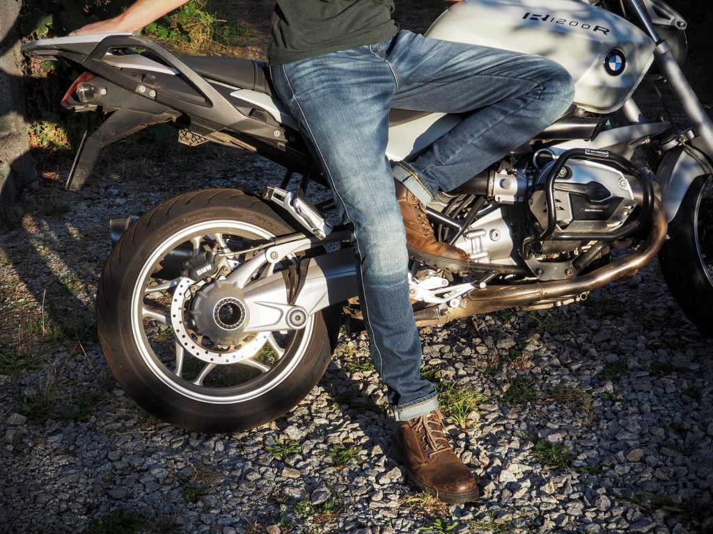 Motard portant un jean moto devant sa moto