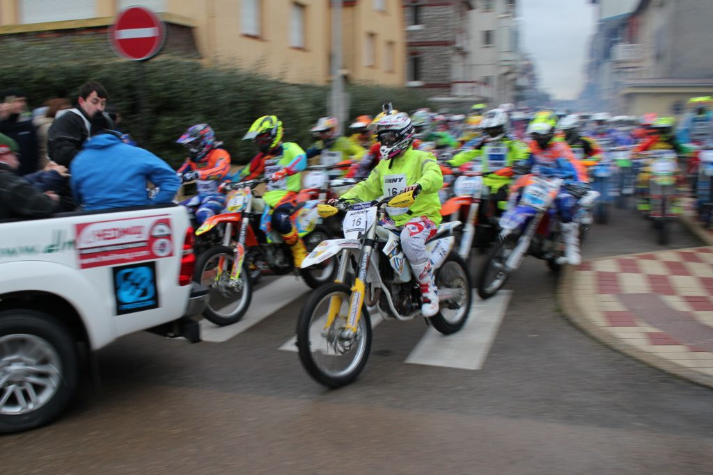 Motos de l'Enduropale en convoi sur le bitume humide de la ville du Touquet