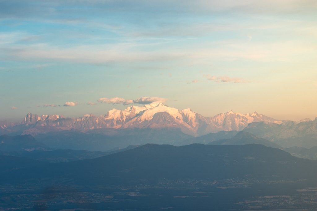 Paysage au crépuscule avec au loin le massif du Mont Blanc éclairé par les derniers rayons du soleil