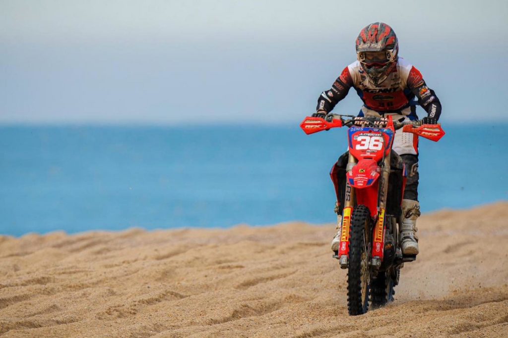 Pilote cross en roulage dans le sable