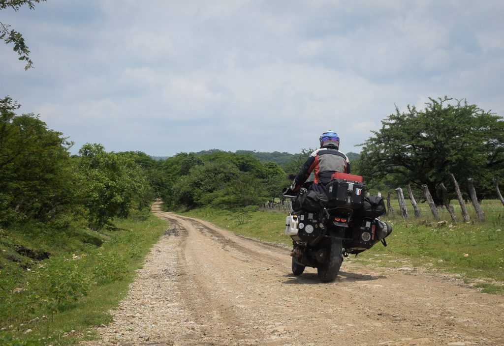 Trail adventure avec un top case roulant sur une piste