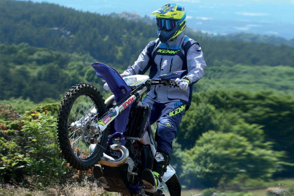 Pilote roulant en enduro avec de l'équipement et des gants moto tout-terrain Kenny