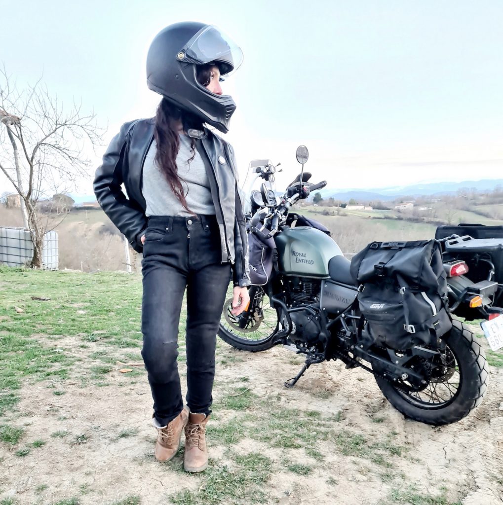 Motarde portant un jean moto posant devant sa Royal Enfield Himalayan