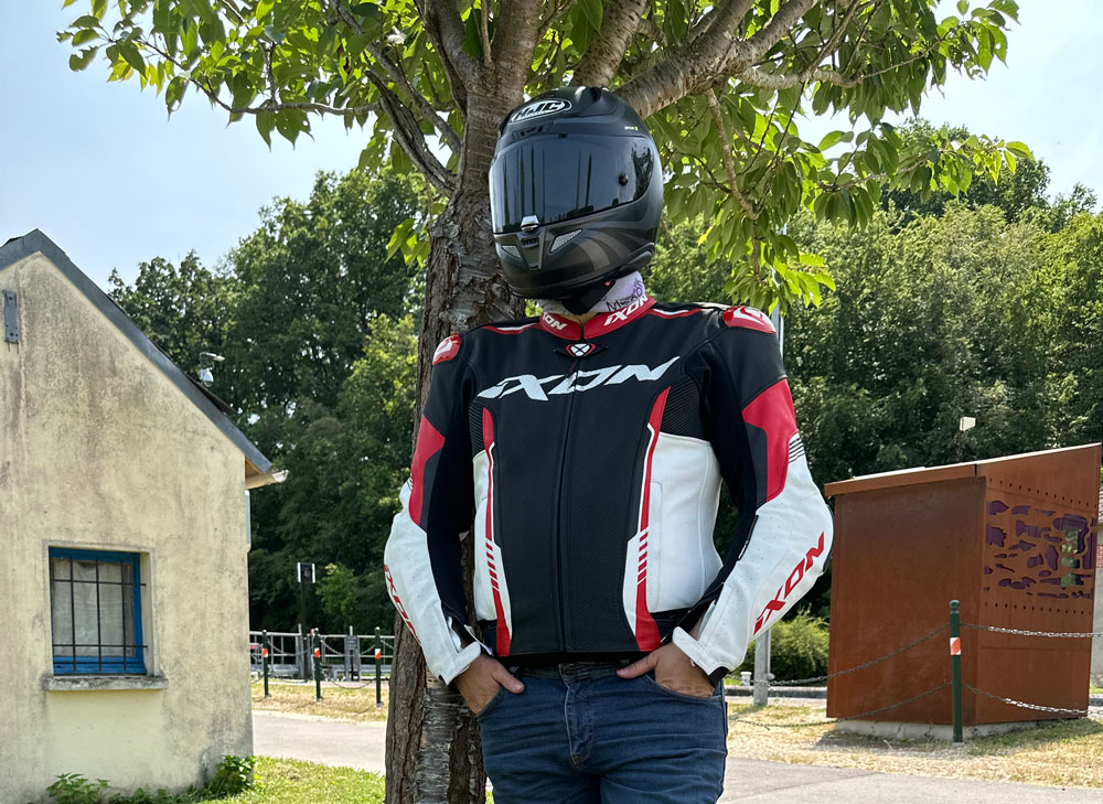 Motard appuyé sur un arbre avec le blouson moto été et mi saison IXON Vortex 2