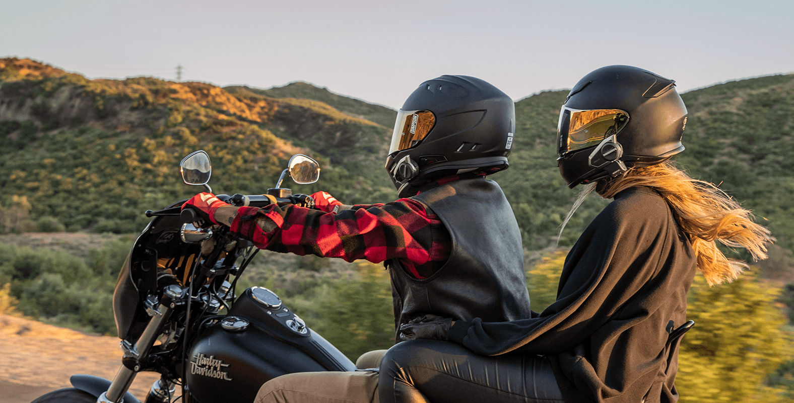 Motard avec une passagère sur une Harley-Davidson, les deux casques sont équipés d'intercoms moto