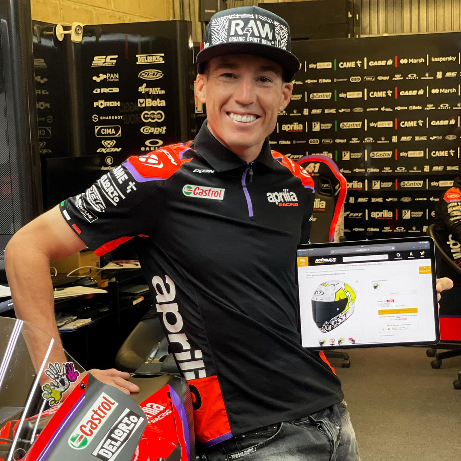 ALeix Espargaro tient une tablette avec la page produit Motoblouz de son casque replica Kyt