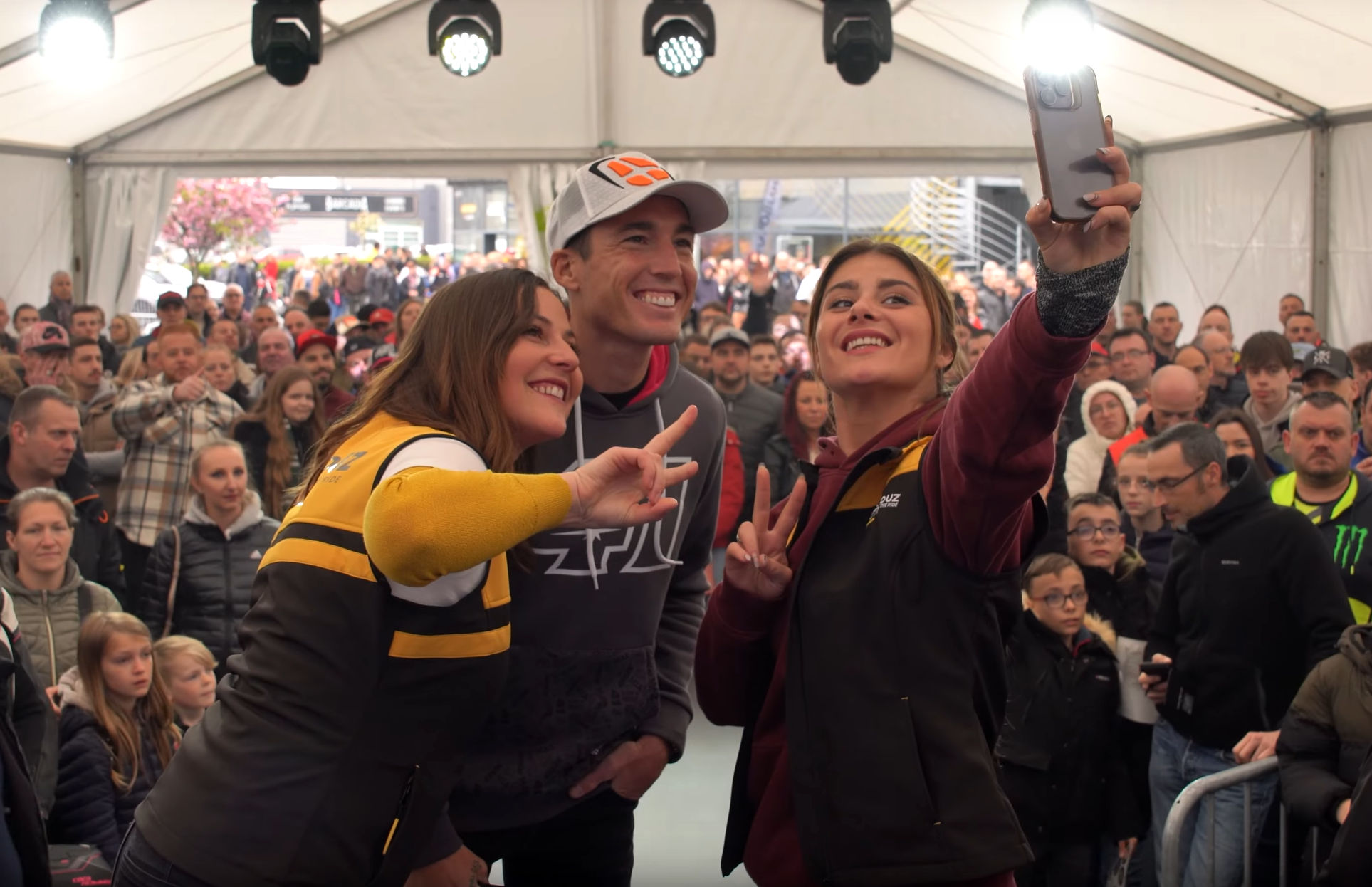 Aleix Espargaro fait un selfie avec deux membres du team Motoblouz devant des centaines de spectateurs au magasin Motoblouz de Seclin (Nord)