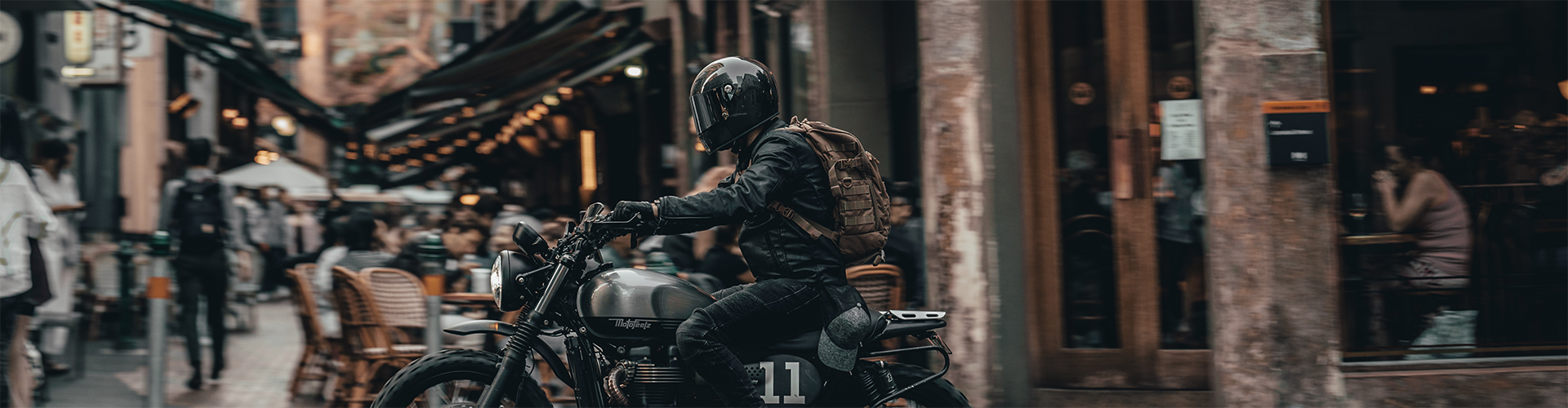 Motard circulant en cafe racer avec un casque integral vintage