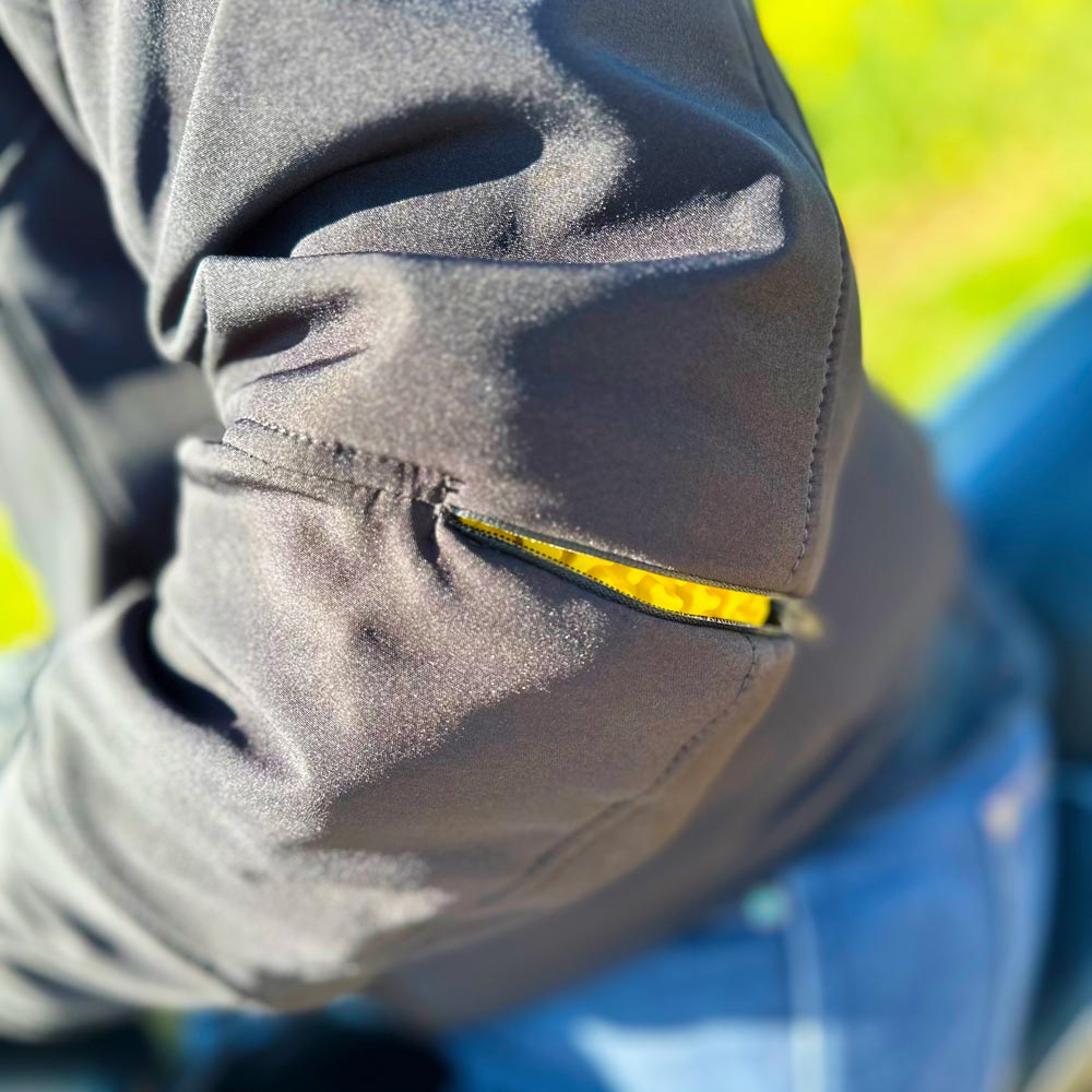 Présentation de l'accès zippé aux protections de coudes réglables par l'extérieur sur la veste moto mi-saison DXR Line